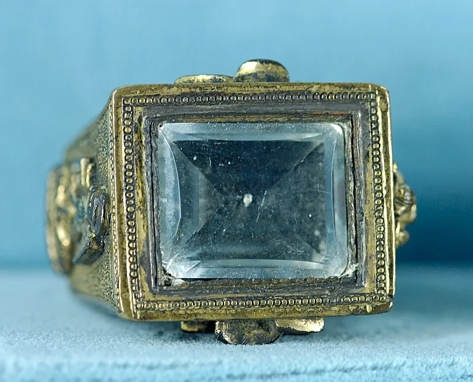 Historic yellow-metal ring with a large rectangular pale-blue stone in a decorated bezel.