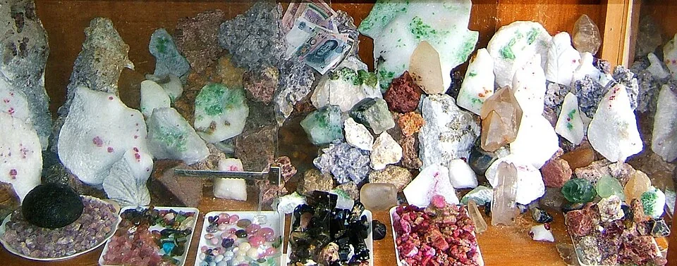 Mineral specimens and polished stones displayed together at a market stall.