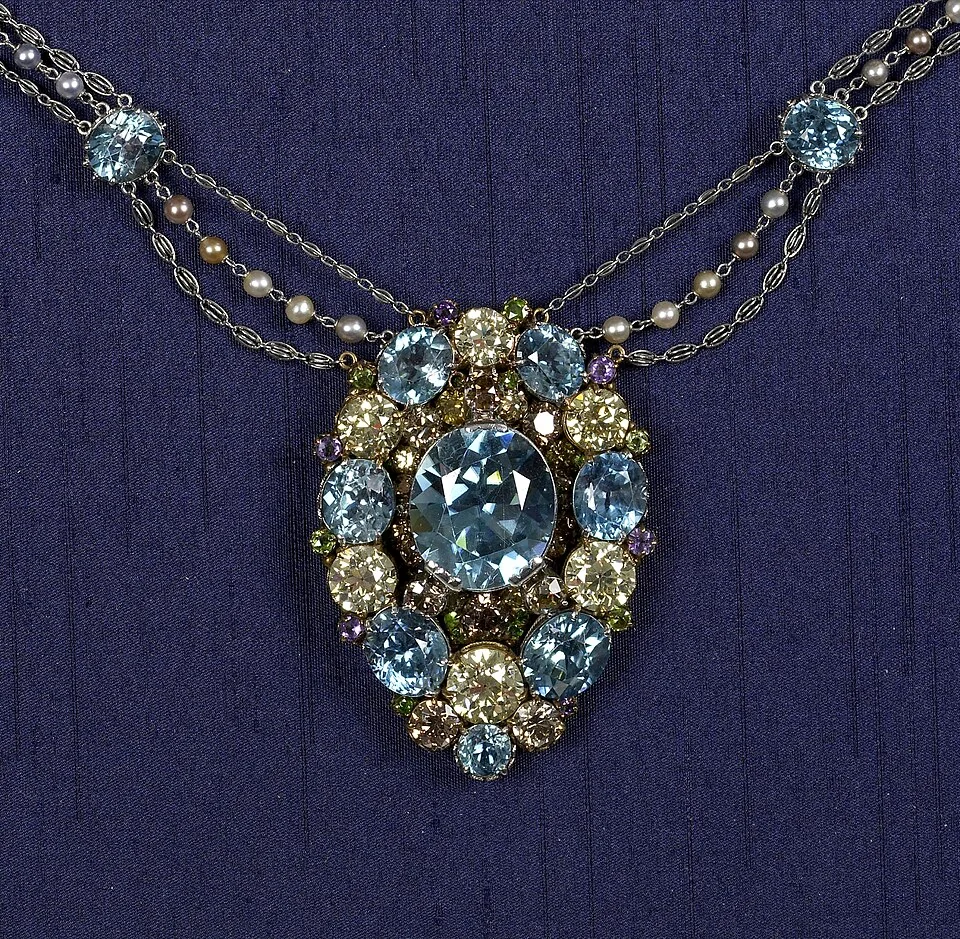 Pale-blue and clear stones arranged in an ornate pendant on a dark background.