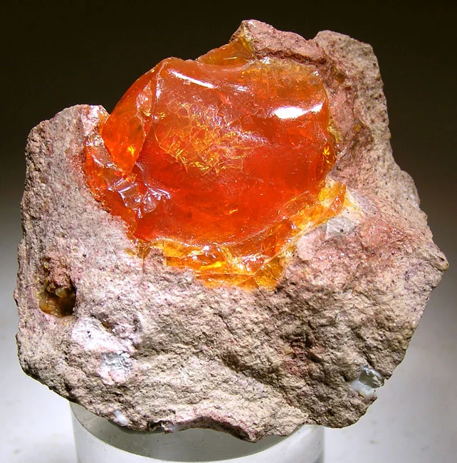 Translucent orange opal-like material embedded in pale host rock.