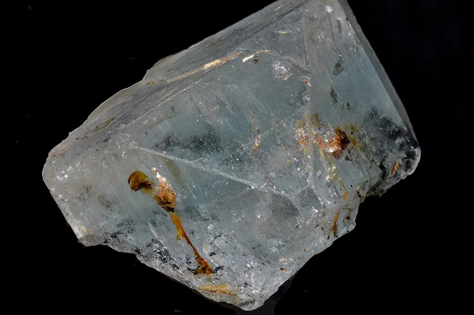 Transparent pale-blue crystal with visible inclusions against a black background.